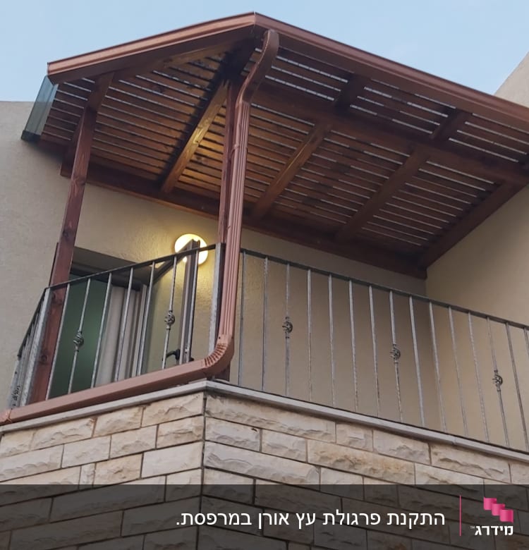 פרגולה מעץ על מרפסת עם מעקה מתכת